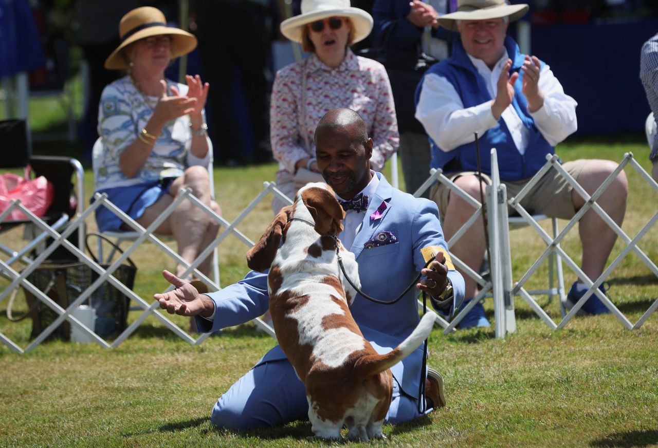 Handler Claudio Cruz embraces Ethan, a basset hound, after winning the "Best of Breed" competition.