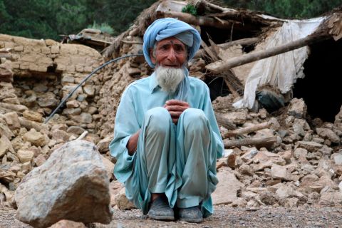 An old man sits near his house that was destroyed in the earthquake on June 22.