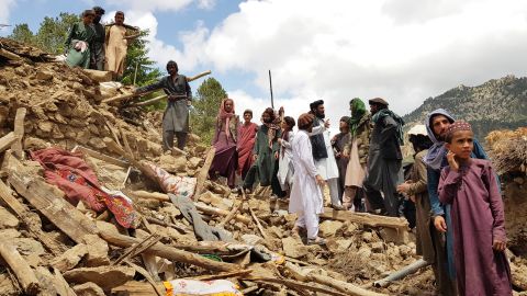 People help in search and rescue operations amid the debris of a building after the earthquake.