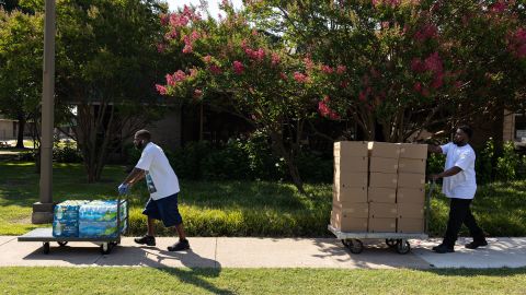 Los voluntarios transportan botellas de agua y refrigerios para repartir entre los residentes del Centro Comunitario Dr. Martin Luther King Jr. durante una ola de calor en Dallas, Texas, el 22 de junio de 2022.