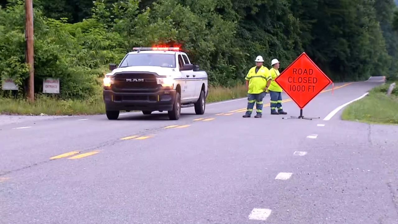 Workers block a road near the site of a helicopter that crash in Logan County, West Virginia.