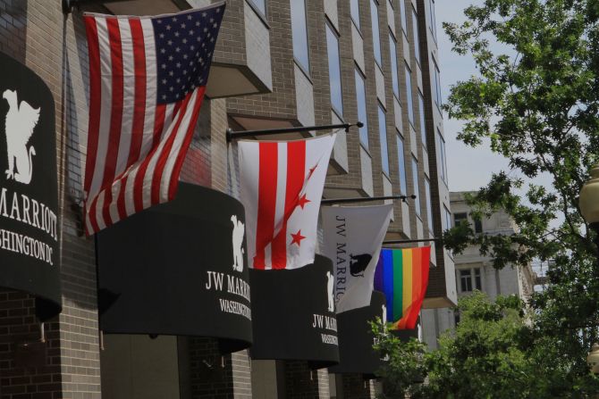 The U.S. and DC flags are flown alongside the Rainbow Flag outside of the J.W. Marriott Hotel in Washington, DC, after a gunman opened fire on a gay night club in Orlando in 2016.   