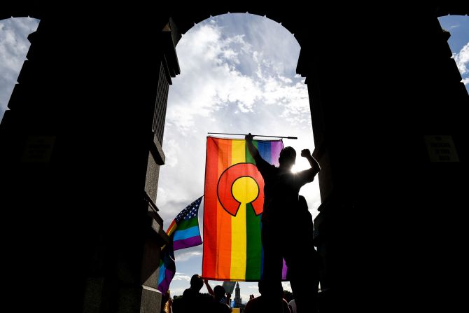 Christopher Savin pumps his fist in frustration as he holds a Colorado pride flag during a 2018 rally at the Colorado State Capitol after the Supreme Court ruled in favor of a bakery that refused to make a wedding cake for a same sex couple. 