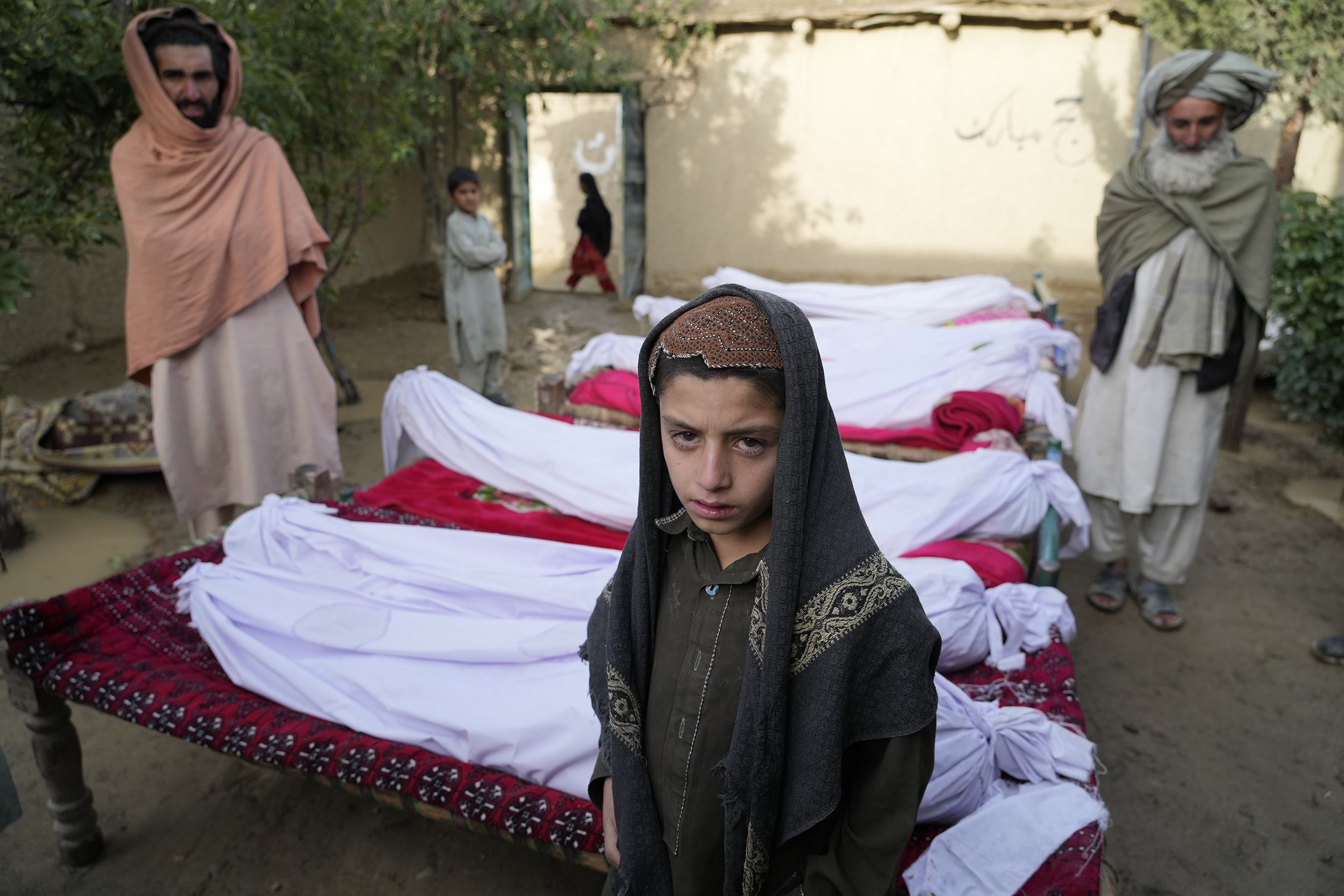 Men stand around the bodies of people killed in an earthquake in Gayan village, in Paktika province, Afghanistan, on June 23.