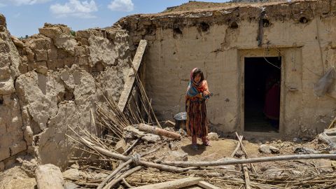 A child stands beside a house damaged by an earthquake in Bernal district, Paktika province, on June 23.