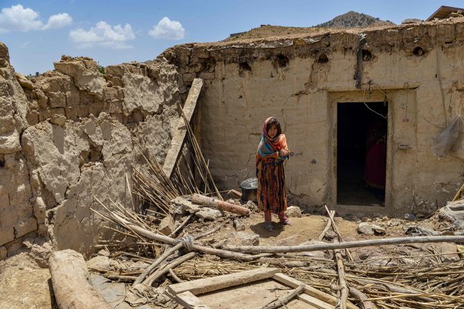 A child stands besides a house damaged by an earthquake in Bernal district, Paktika province, on June 23.