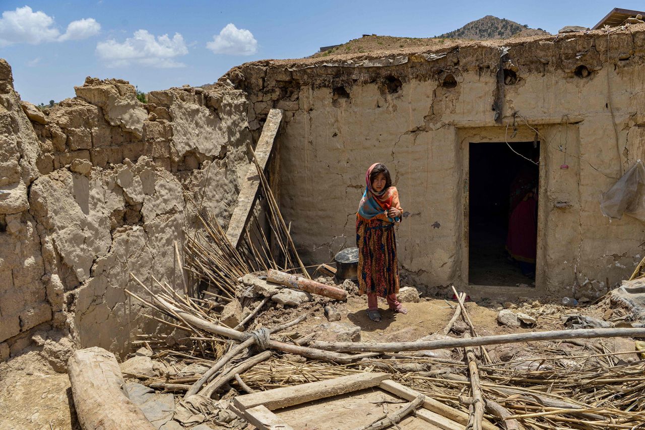A child stands besides a house damaged by an earthquake in Bernal district, Paktika province, on June 23.