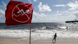 A boy plays on the beach as a No Swimming flag flies, Saturday, Aug. 31, 2019, in Lake Worth, Fla. Hurricane Dorian is bearing down on the northwestern Bahamas as a Category 4 storm. Forecasters say Dorian is then expected to go up the Southeast coastline.
