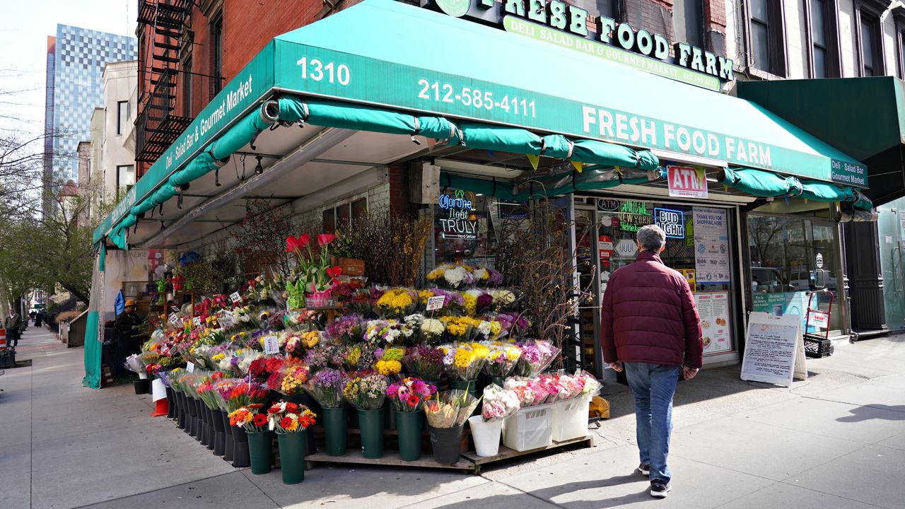 A view of a bodega selling colorful flowers in New York City.
