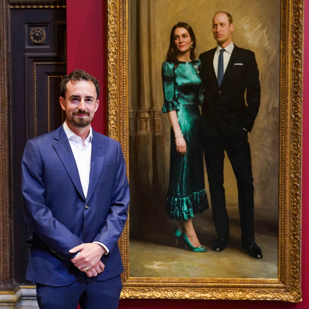 British artist Jamie Coreth poses with his painting of Britain's Prince William, Duke of Cambridge, and Britain's Catherine, Duchess of Cambridge, unveiled at the Fitzwilliam Museum in Cambridge on June 23, 2022. 