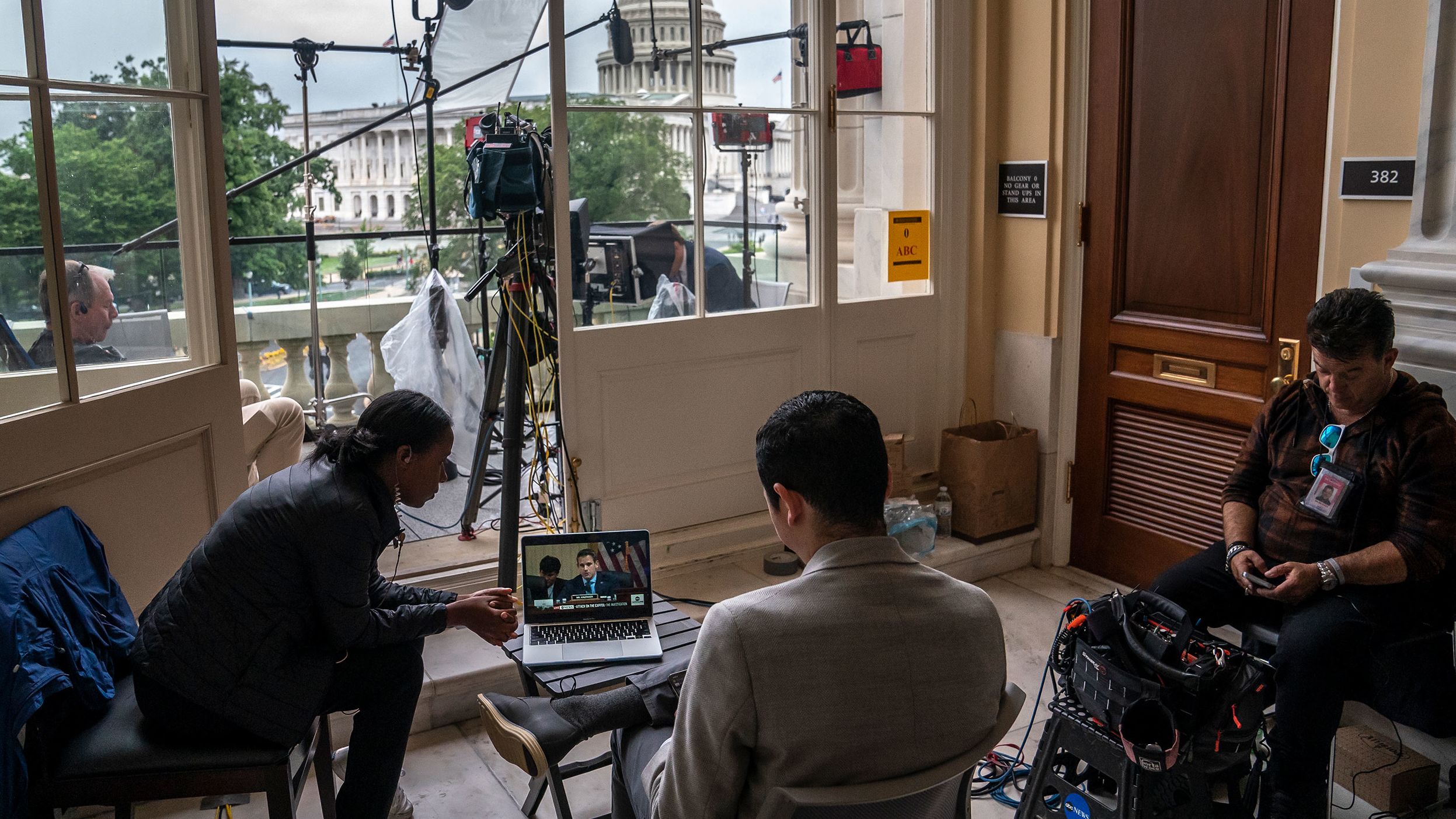 Journalists watch the June 23 hearing on a laptop outside the hearing room.