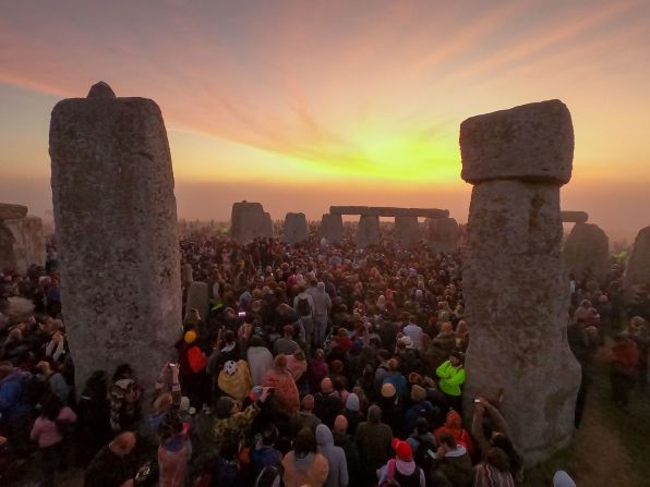 People gather for the sunrise for the summer solstice at Stonehenge in Wiltshire, England on Tuesday, June 21. It is the longest day of the year in the Northern Hemisphere. 