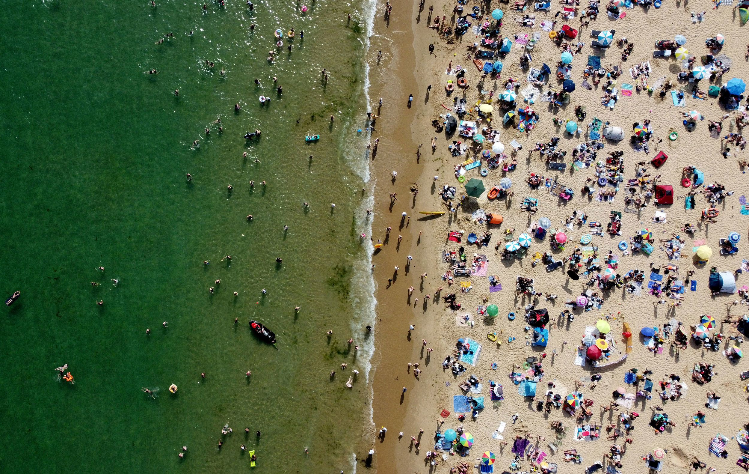 Beachgoers enjoy the hot weather in Bournemouth, England.