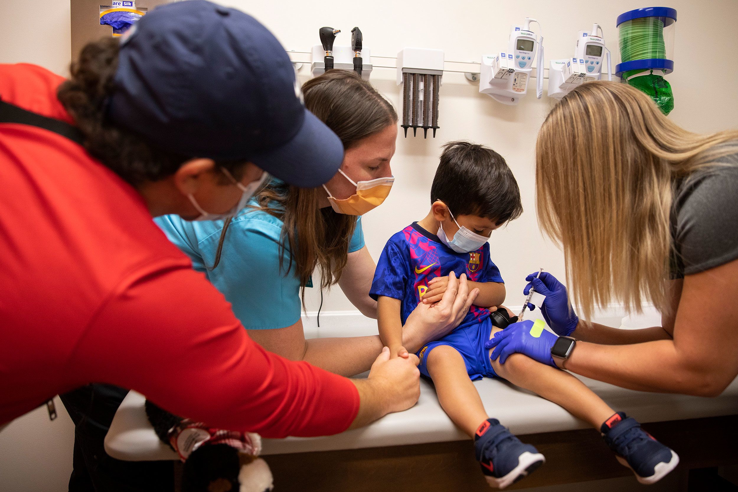 Brian Wentzel holds the hand of his son while he receives his Covid-19 vaccination at Dayton Children's Hospital in Ohio.