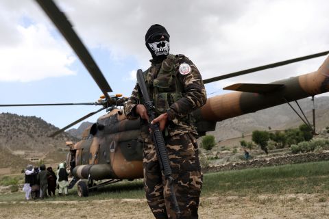 A Taliban fighter stands guard next to a helicopter in Gayan, Afghanistan, on June 23.