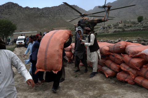 A man carries supplies in an area affected by the earthquake in Gayan, Afghanistan, on June 23.