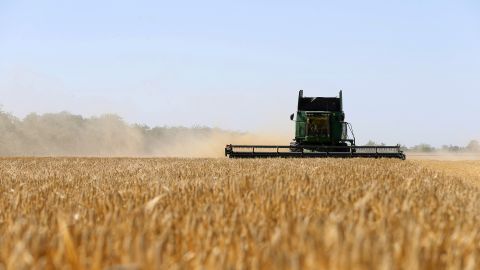 یوکرین کے کسان 22 جون 2022 کو یوکرین کے علاقے اوڈیسا میں جو کے کھیتوں کی کٹائی کر رہے ہیں۔