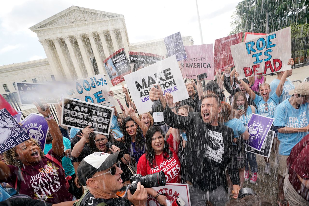 Anti-abortion demonstrators celebrate with champagne in front of the Supreme Court.
