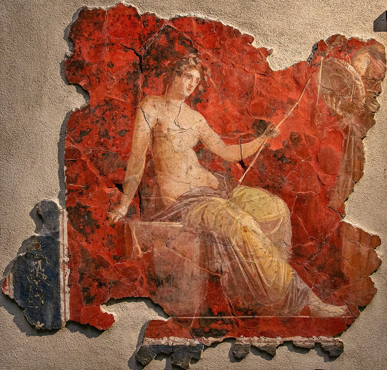 Dionysus, the god of wine, also known as Bacchus, depicted against a red background.