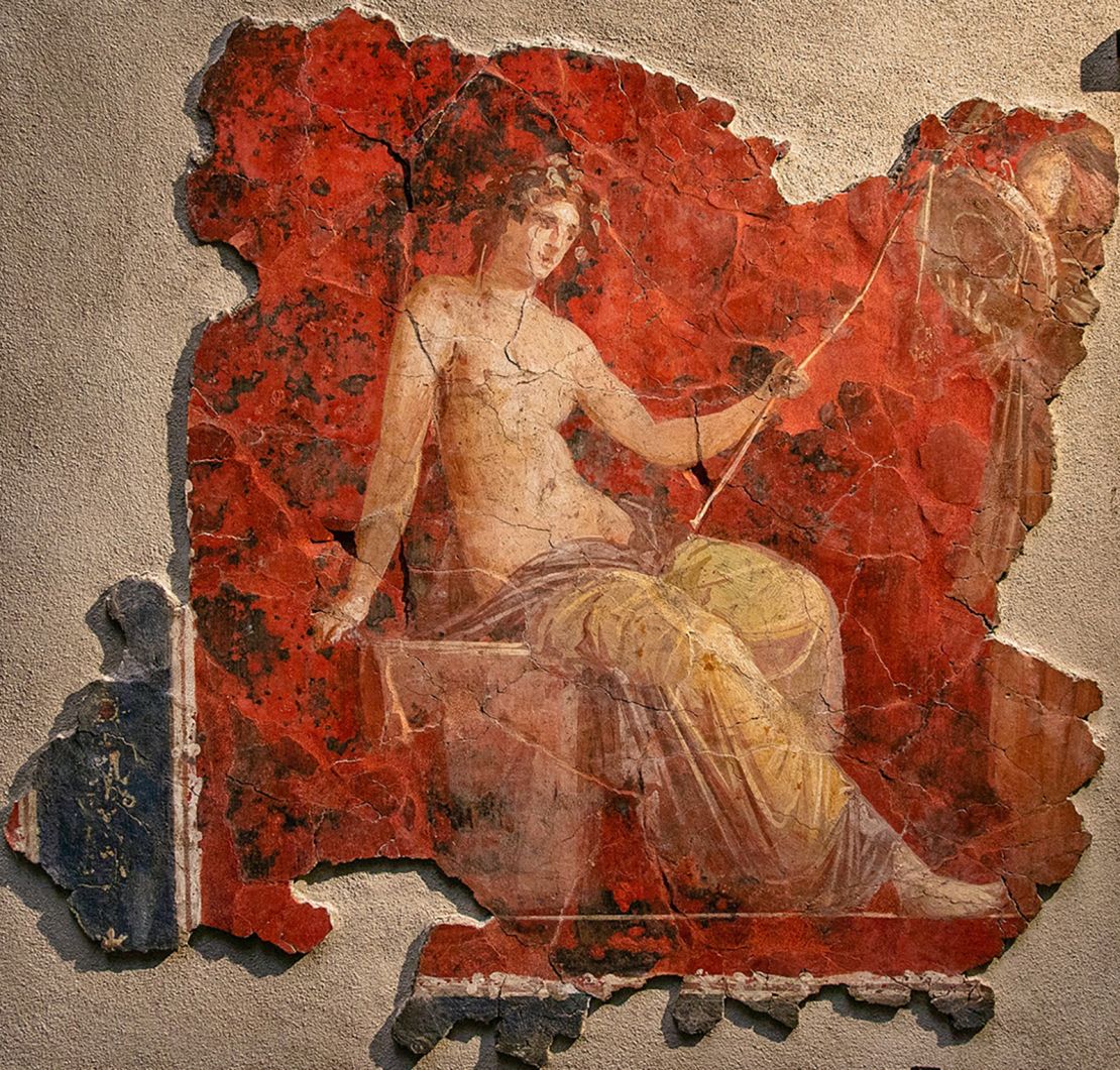 Dionysus, the god of wine, also known as Bacchus, depicted against a red background.