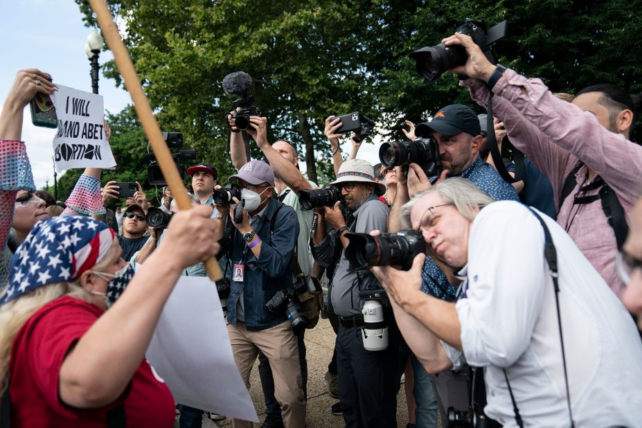 Journalists photograph reactions outside the Supreme Court on Friday.