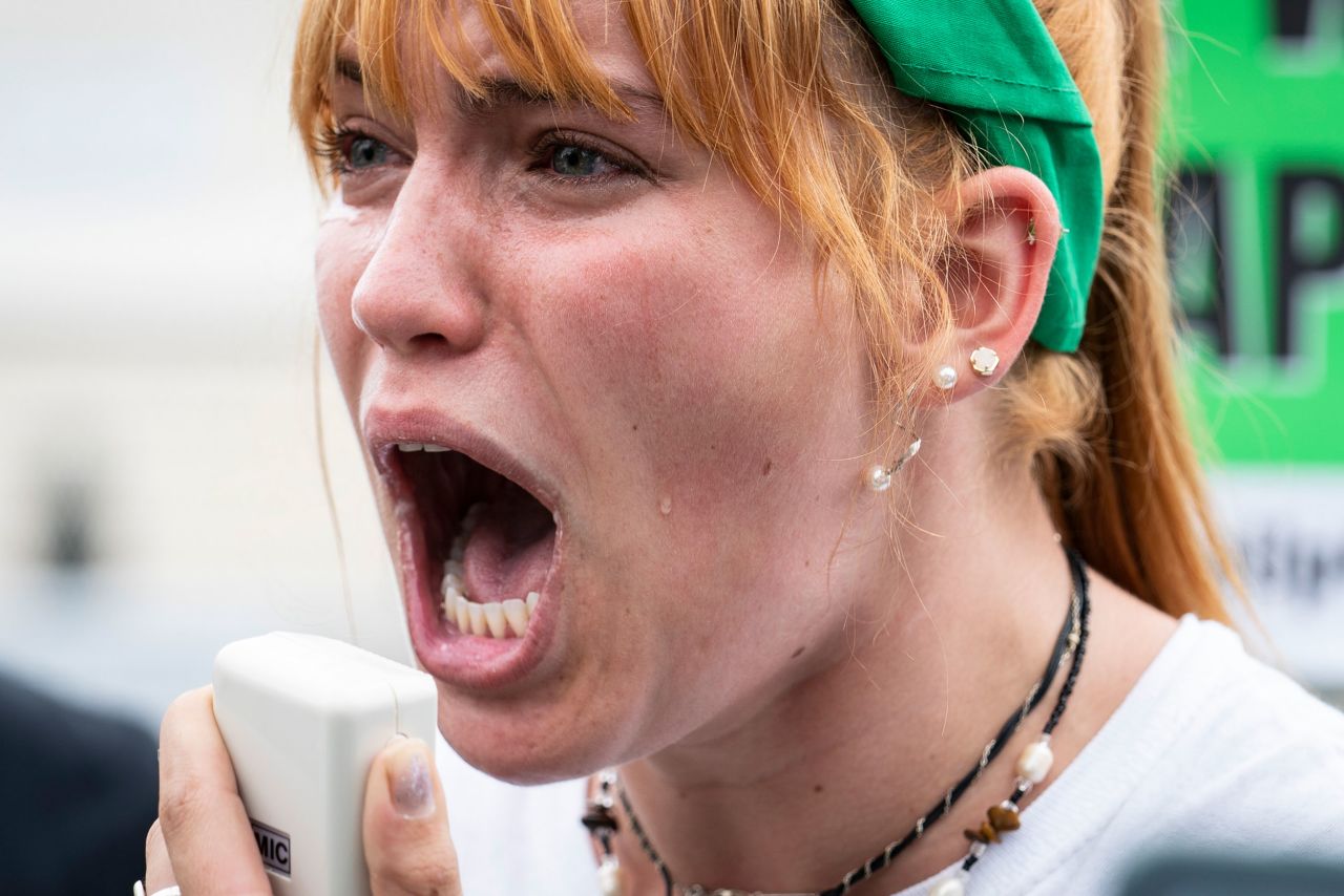 A tear rolls down the cheek of an abortion rights activist in Washington, DC, on Friday. Moments after the ruling was announced, the woman used a bullhorn to share her experience with sexual assault. She shared she would have taken her own life if she had become pregnant and not had access to reproductive health care. 