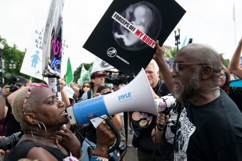 Отляво, активист за правата на абортите и демонстрант против абортите спорят пред Върховния съд.
