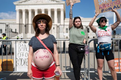 Amanda Herring, left, poses for a portrait with the words "not yet a human" written on her pregnant belly during an abortion rights demonstration in front of the Supreme Court on Friday. Herring, who is Jewish, told CNN that her religion has helped shape her views on abortion. "Judaism says that life begins with the first breath, that is when the soul enters the body," she said.
