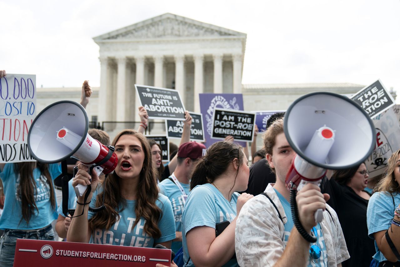 Noah Slayter, right, demonstrates with fellow anti-abortion activists in front of the Supreme Court on Friday. "I was here right when the decision was delivered," said Slayter. "I am ecstatic. I was walking on air earlier."