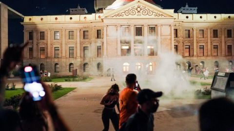 Arizona State Troopers deploy tear gas as they confront protestors outside the Capitol building.