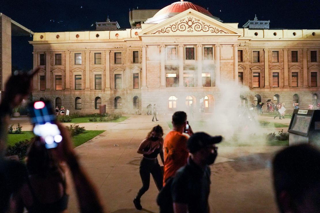 Arizona State Troopers deploy tear gas as they confront protestors outside the Capitol building.