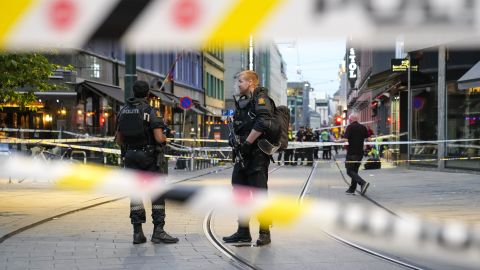 Police stand guard at the site of a mass shooting in Oslo, early Saturday.