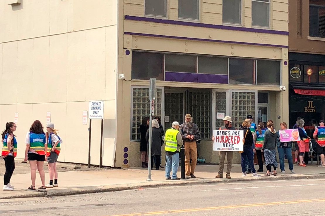 A photo from May shows both protesters and patient escorts in rainbow-colored vests outside of Red River Women's Clinic.