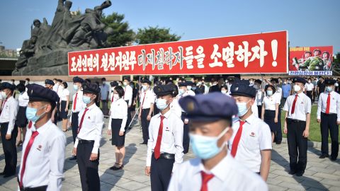 In this photo taken on June 25, people hold a banner that translates as "Let us drive out the US Imperialism and reunify the fatherland!" on the 72nd anniversary of the three-year Korean War, in Pyongyang.