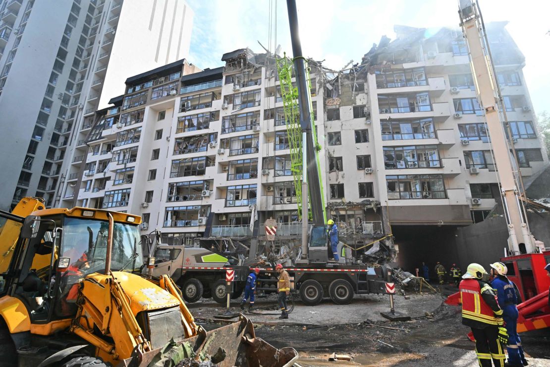 Ukrainian rescuers work outside a residential building hit by Russian missiles in Kyiv in June.