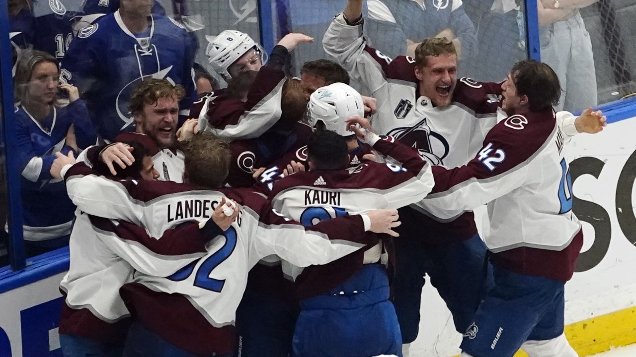 Avalanche players gather at the boards, celebrating their victory in Game 6.