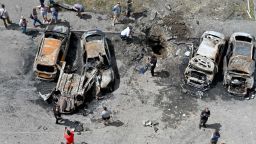 TOPSHOT - Bystanders gather around the wreckage of vehicles and a crater after Russian missiles struck the courtyard of a multi-storey residential complex on the eastern outskirts of Kharkiv on June 26, 2022, amid the Russian invasion of Ukraine. (Photo by SERGEY BOBOK / AFP) (Photo by SERGEY BOBOK/AFP via Getty Images)