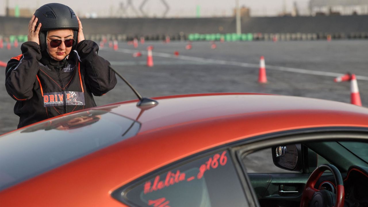 Afnan Almarglani, the first Saudi woman to be certified as an autocross instructor, adjusts her helmet in front of her car at Derab circuit in the Saudi Arabian capital Riyadh on June 26.