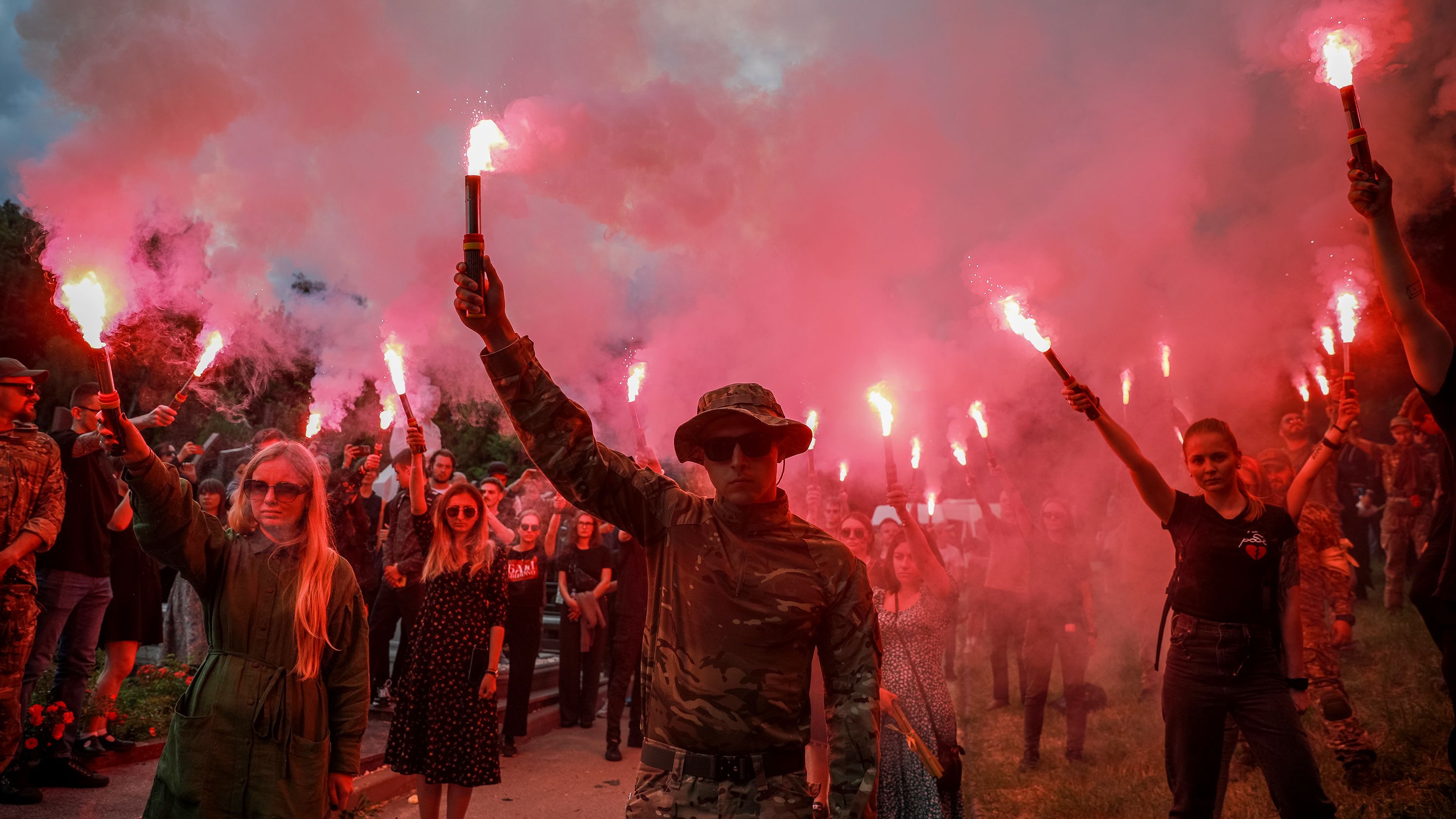 People light flares in memory of the Ukrainian activist Roman Ratushnyi during a farewell ceremony at Baikove cemetery, Kyiv, Ukraine, on June 18.