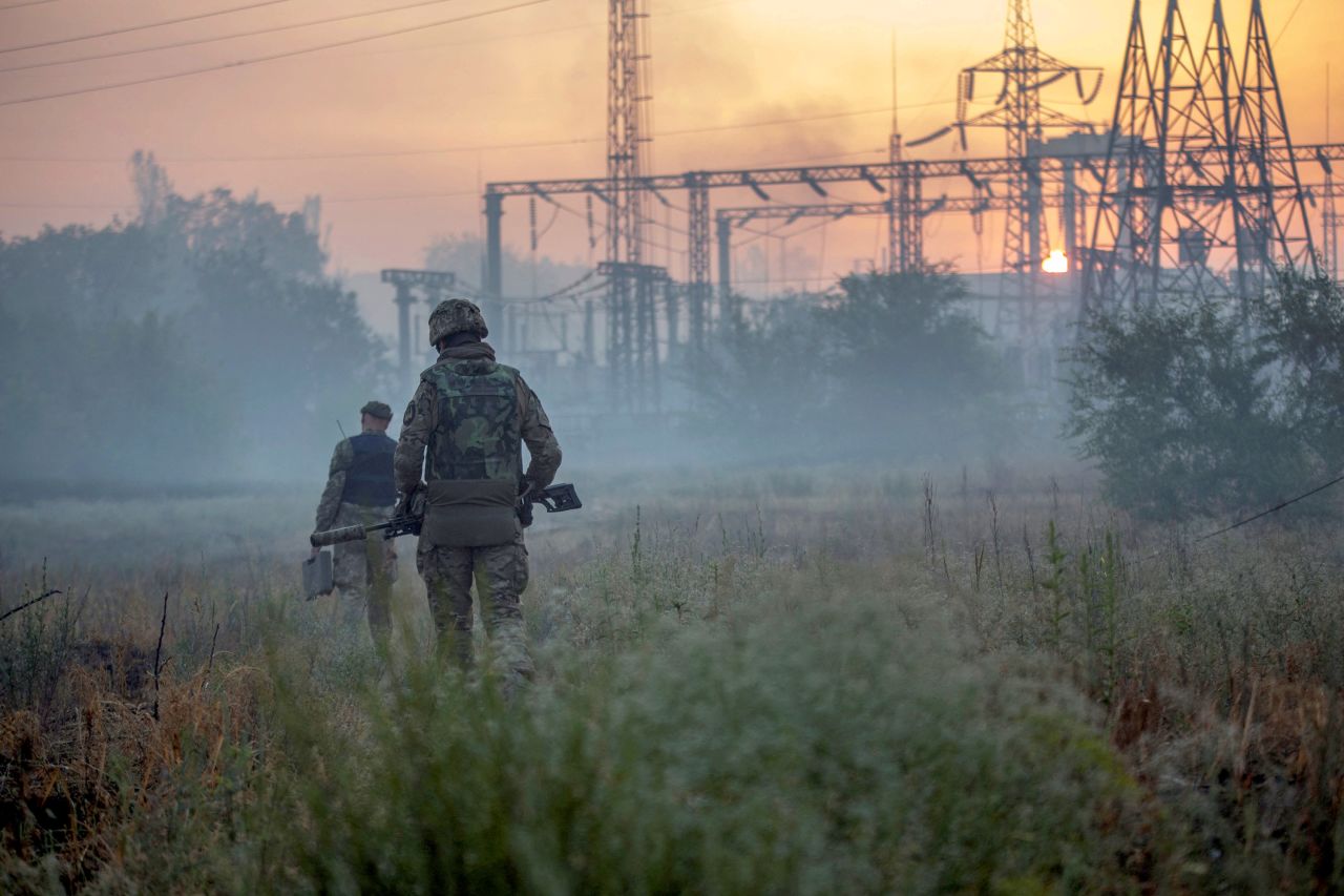 Ukrainian service members patrol an area in the city of <a target=