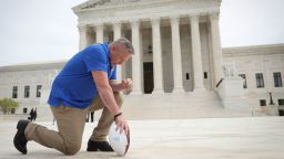 WASHINGTON, DC - APRIL 25: Former Bremerton High School assistant football coach Joe Kennedy takes a knee in front of the U.S. Supreme Court after his legal case, Kennedy vs. Bremerton School District, was argued before the court on April 25, 2022 in Washington, DC. Kennedy was terminated from his job by Bremerton public school officials in 2015 after refusing to stop his on-field prayers after football games.  