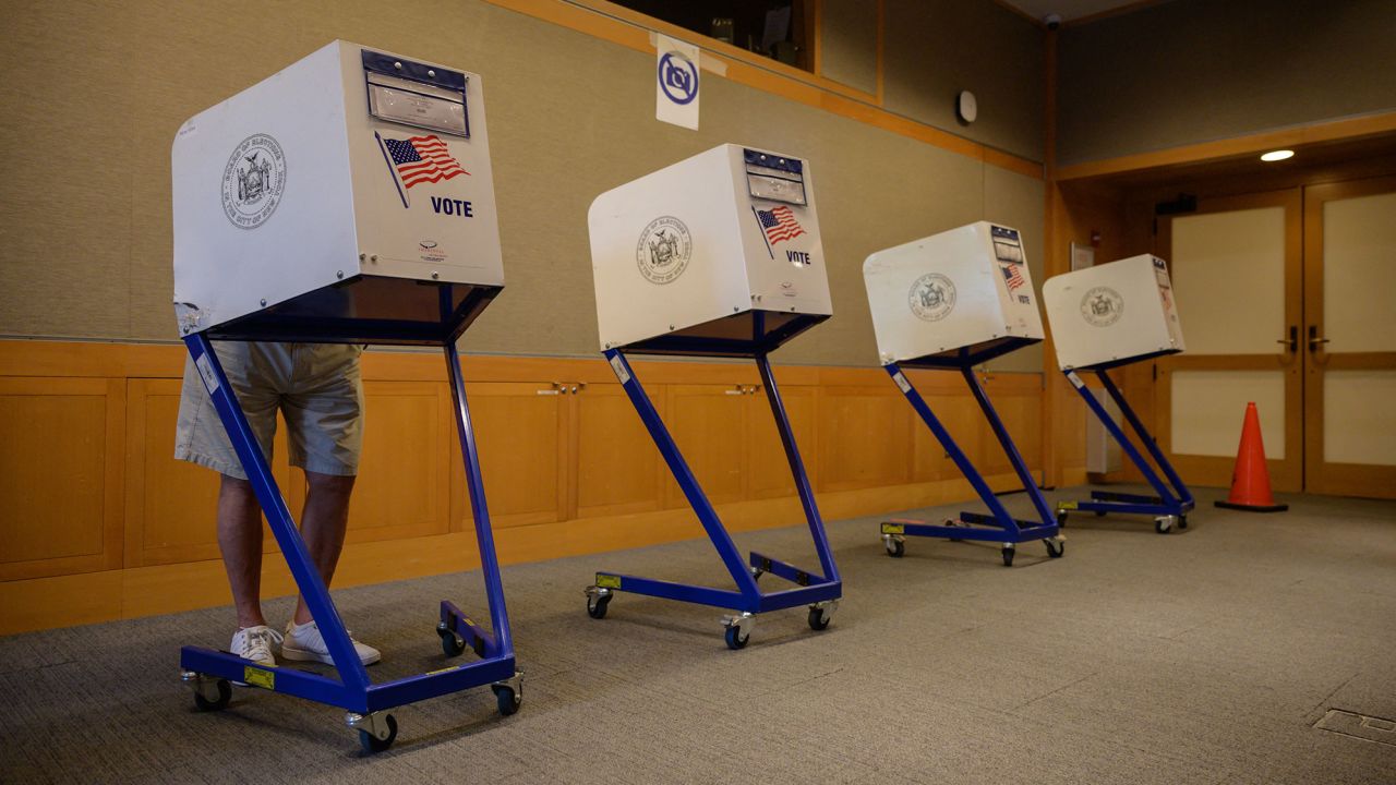 A voter stands in a booth at a voting station at the Metropolitan Museum of Art (MET) during the mayoral election process in New York on June 12, 2021. 