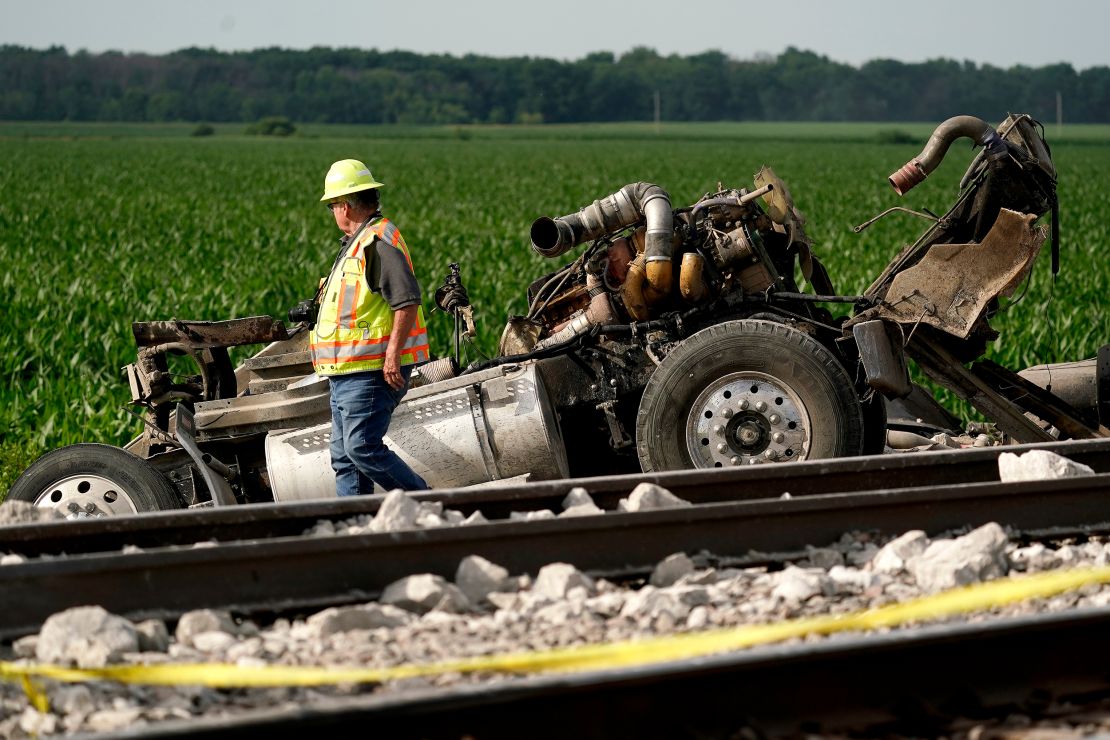 A worker looks over the chassis of a dump truck hit by an Amtrak train on Monday.