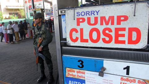 A member of the Sri Lankan security personnel stands guard outside a fuel station that ran out of gasoline in Colombo on June 27.