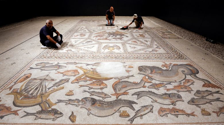 Workers clean a restored Roman-era mosaic after it was put on display at its original site in Lod, now an Israeli city where an archaeological centre has been inaugurated, Israel June 27, 2022. REUTERS/ Amir Cohen
