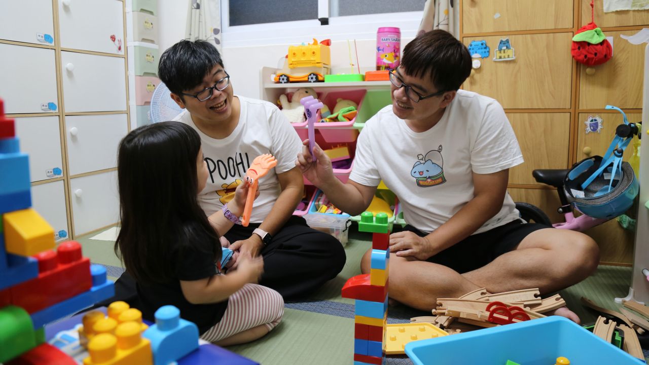 Taiwanese couple Wang Chen-wei (left) and Chen Jun-ru play with their daughter, Joujou, inside their apartment in Kaohsiung.