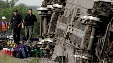 Сотрудники правоохранительных органов изучают кадры поезда Amtrak, который сошел с рельсов после столкновения с самосвалом в понедельник недалеко от Мендона, штат Миссури.