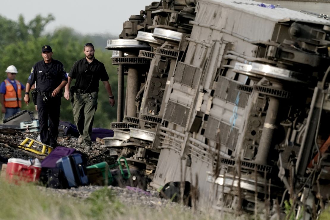 Law enforcement personnel inspect the scene of an Amtrak train that derailed after striking a dump truck Monday near Mendon, Missouri.