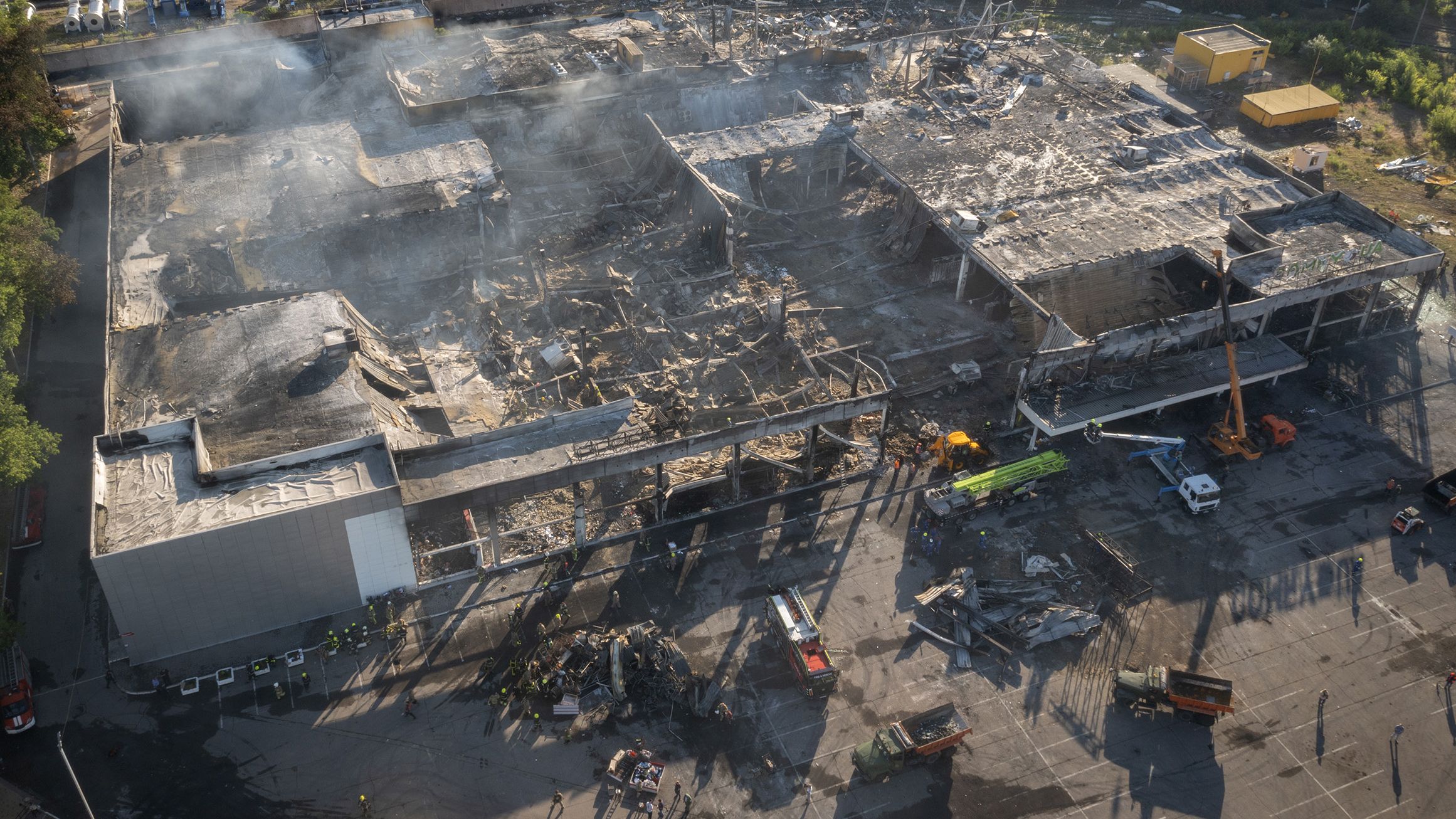 Ukrainian State Emergency Service firefighters work to take away debris at a shopping mall after a <a href="https://edition.cnn.com/europe/live-news/russia-ukraine-war-news-06-28-22/h_f2e4cf15367437c654d2db5ed8fa9349" target="_blank">rocket attack in Kremenchuk</a>, Ukraine, on June 28.