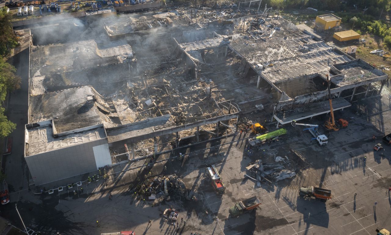 Ukrainian State Emergency Service firefighters work to take away debris at a shopping mall after a <a target=